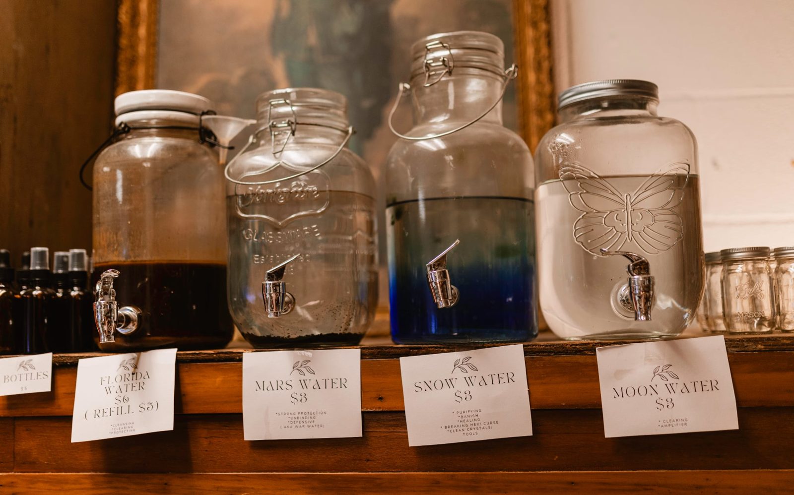 Hand-labeled moon water and sun water jars on a wooden shelf